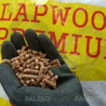 Pellet lapwood w worku rozsypany, pellet w ręce luzem, biały worek z żółtym i czerwonym elementem płomienia, tytuł czerwony Lapwood premium na żółtym tle