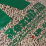 Pellet drzewny Rezult w przezroczystym worku z zielonymmi napisami, leżący worek, zbliżenie na napis Rezult