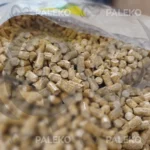 pellet drzewny RIO, jasny pellet, szaro-beżowy worek z niebieskim paskiem, luzny pellet rozsypany