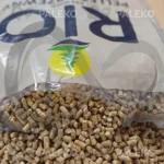 pellet drzewny RIO, jasny pellet, szaro-beżowy worek z niebieskim paskiem, otwarty worek z pelletem