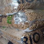 pellet drzewny RIO, jasny pellet, szaro-beżowy worek z niebieskim paskiem, worki na sobie na palecie, pionowo