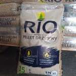 pellet drzewny RIO, jasny pellet, szaro-beżowy worek z niebieskim paskiem, worek przed paletą, zbliżenie